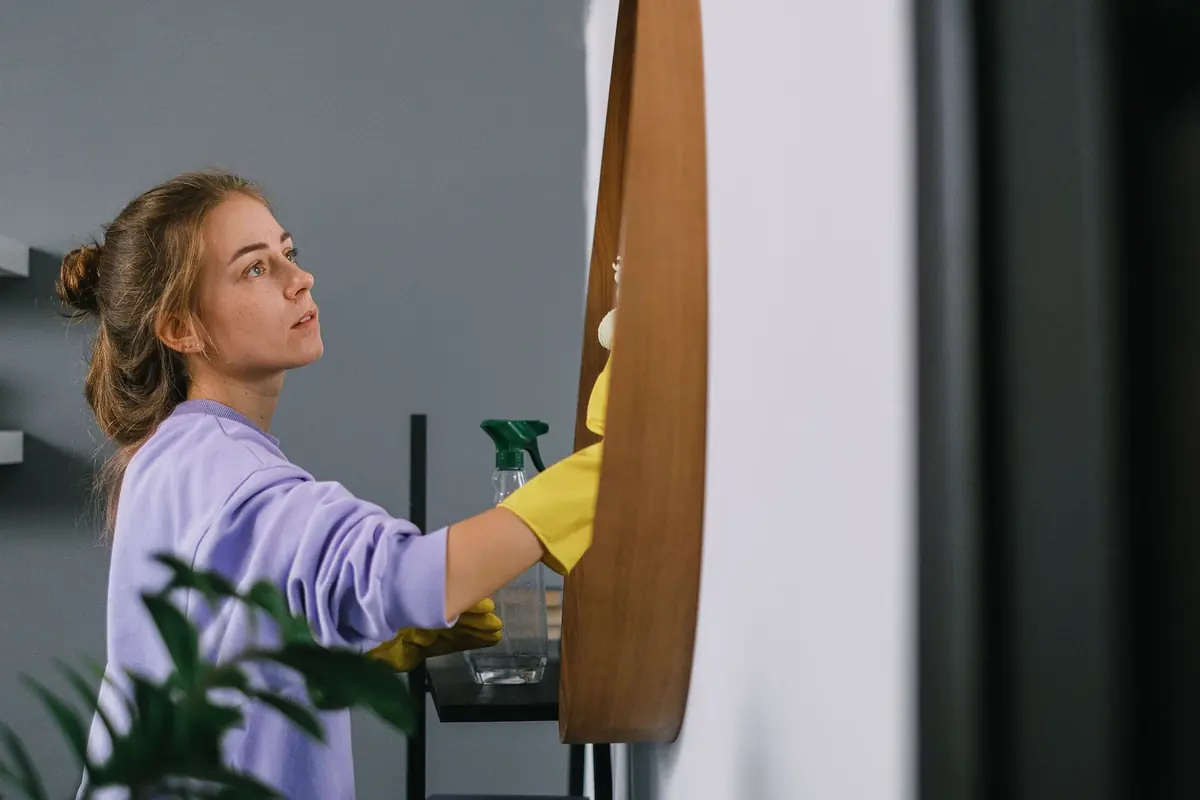 Cleaner wiping down a surface in an office